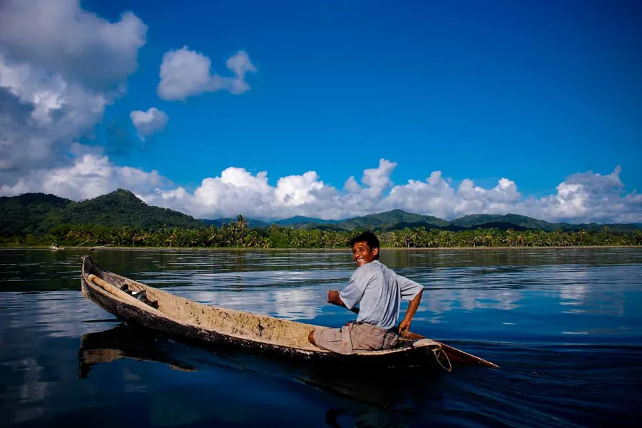 A fisher paddling a dugout canoe in Kuna Yala